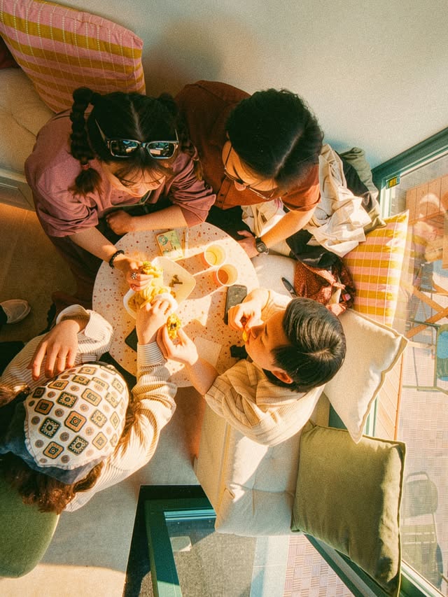 Des amis partagent un moment ensemble à une table près de la fenêtre chez PANÈA